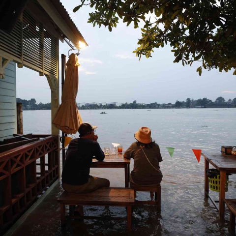 صور: مطعم يجذب الزبائن بتناول الطعام وسط مياه الفيضانات في تايلند!
